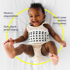 A woman relaxing on a couch with a suitcase, near a Nanit Pro Smart Baby Monitor for baby monitoring.