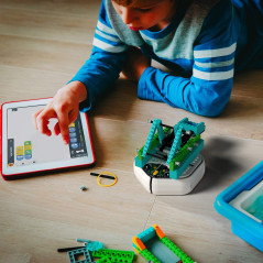 iRobot Root rt0 coding robot engaging in creative play with a green and white box.